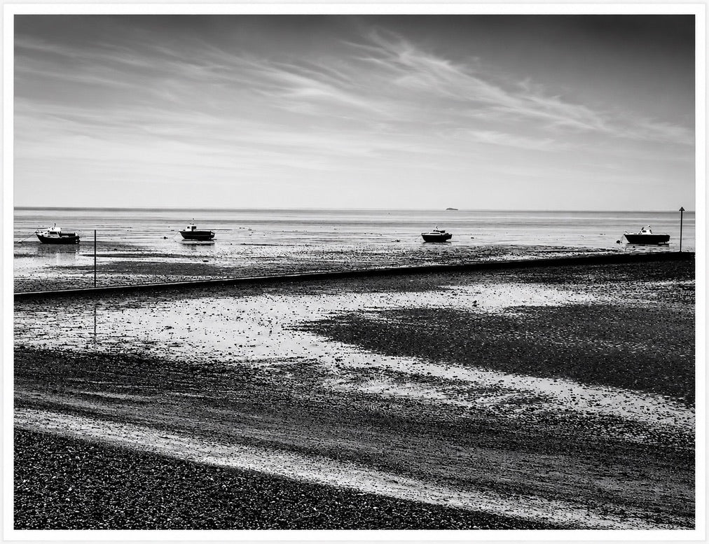 Four boats at low tide, in monochrome